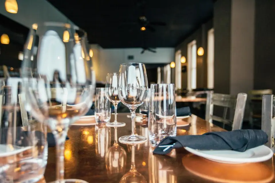 Set tables with wine glasses in a warm restaurant
